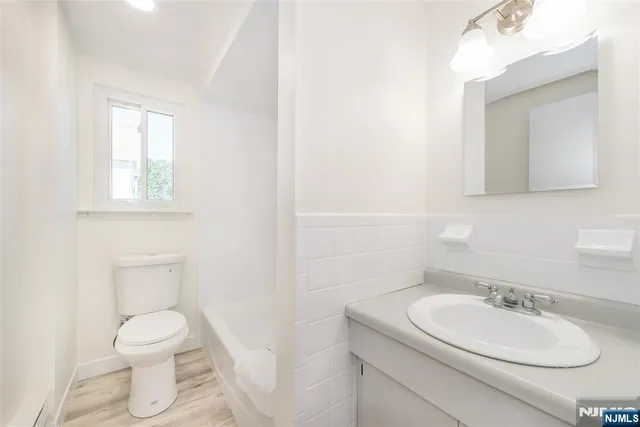 a bathroom with a granite countertop toilet sink and mirror