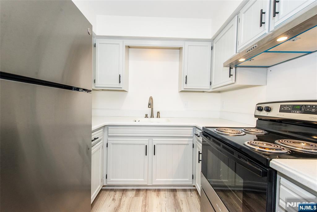 79 Getty Avenue, Unit 4B Clifton, NJ 07011 - Photo 3 of 30 a kitchen with white cabinets and appliances