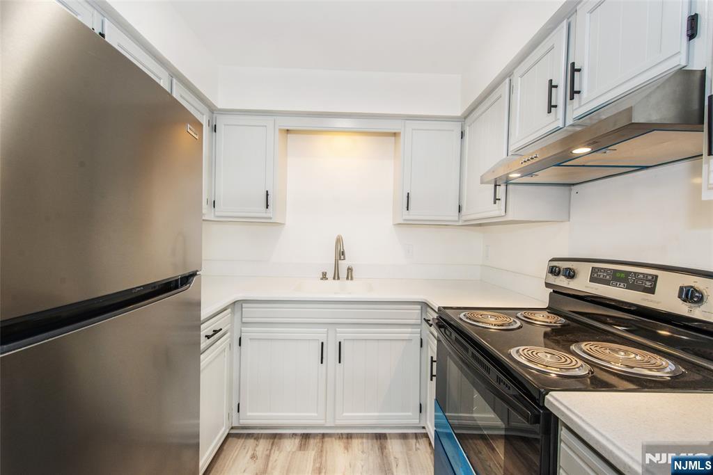 79 Getty Avenue, Unit 4B Clifton, NJ 07011 - Photo 4 of 30 a kitchen with white cabinets stainless steel appliances and sink