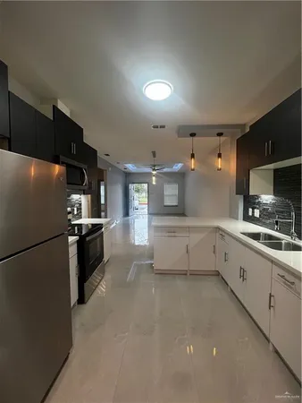 a kitchen with stainless steel appliances a refrigerator sink and white cabinets