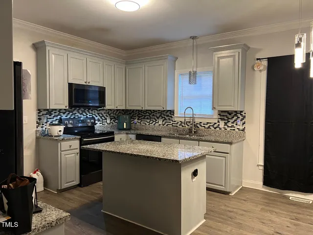 a kitchen with stainless steel appliances granite countertop a sink stove and microwave