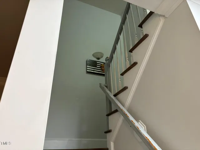a view of a hallway with wooden floor and staircase