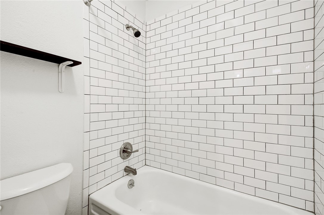 4111 Avenue A, Unit 108 Austin, TX 78751 - Photo 15 of 17 a bathroom with a white bathtub and a toilet