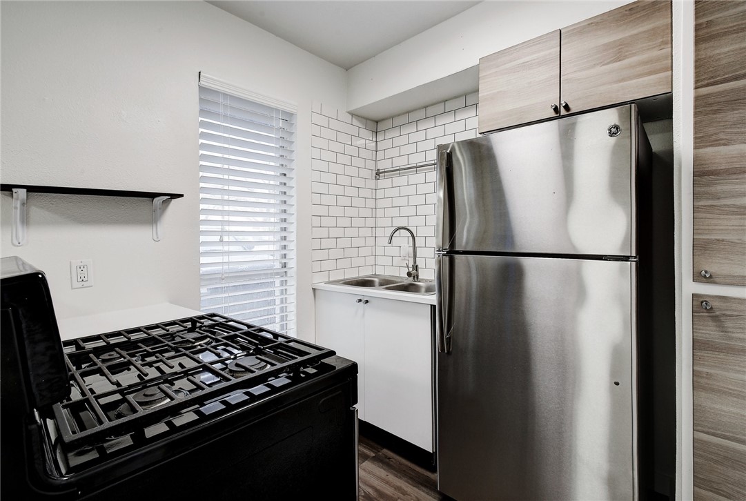 4111 Avenue A, Unit 108 Austin, TX 78751 - Photo 6 of 17 a kitchen with stainless steel appliances granite countertop a refrigerator and a sink