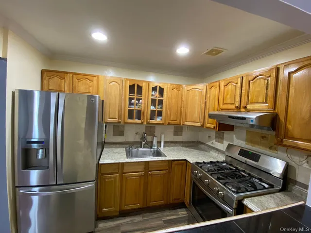a kitchen with stainless steel appliances granite countertop a refrigerator stove and sink