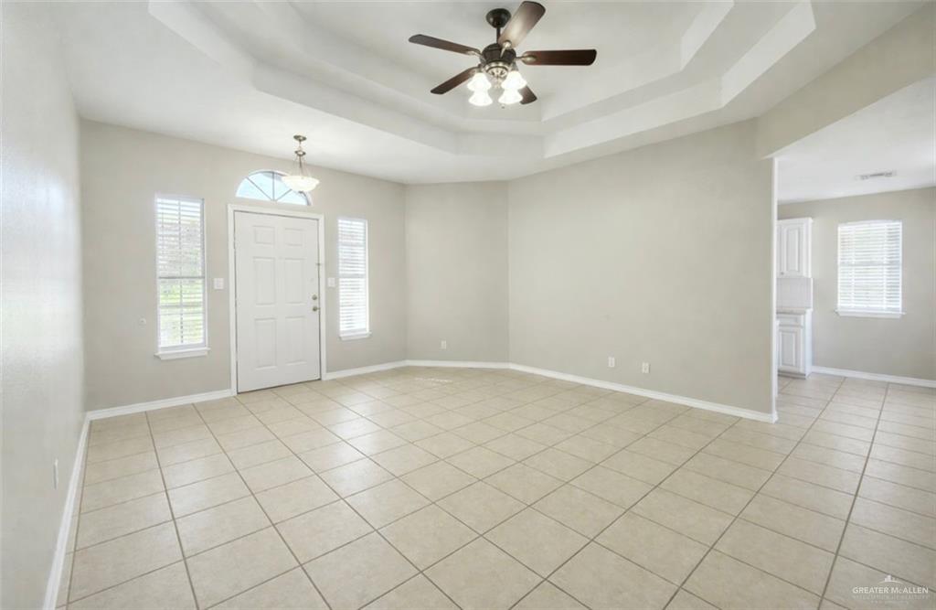 2115 East 29th Street Mission, TX 78574 - Photo 5 of 18 an empty room with chandelier fan and windows