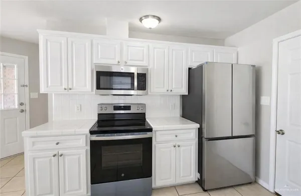 a kitchen with a refrigerator stove and microwave