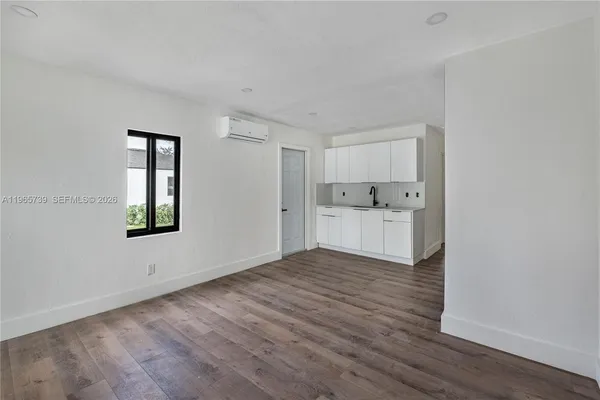 a view of empty room with wooden floor and window