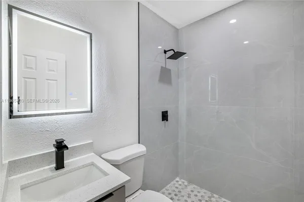 a bathroom with a sink a toilet and shower