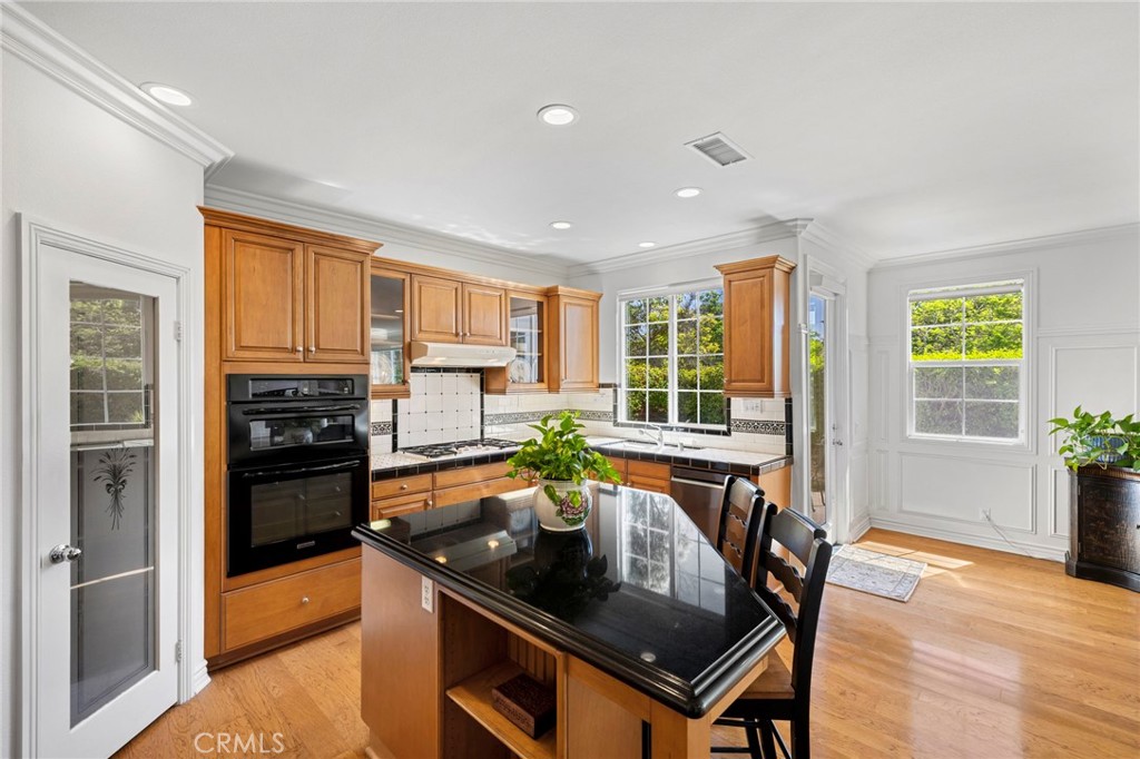 30 Baudin Circle Ladera Ranch, CA 92694 - Photo 24 of 75 a kitchen with stainless steel appliances granite countertop a stove a refrigerator a sink a dining table and chairs
