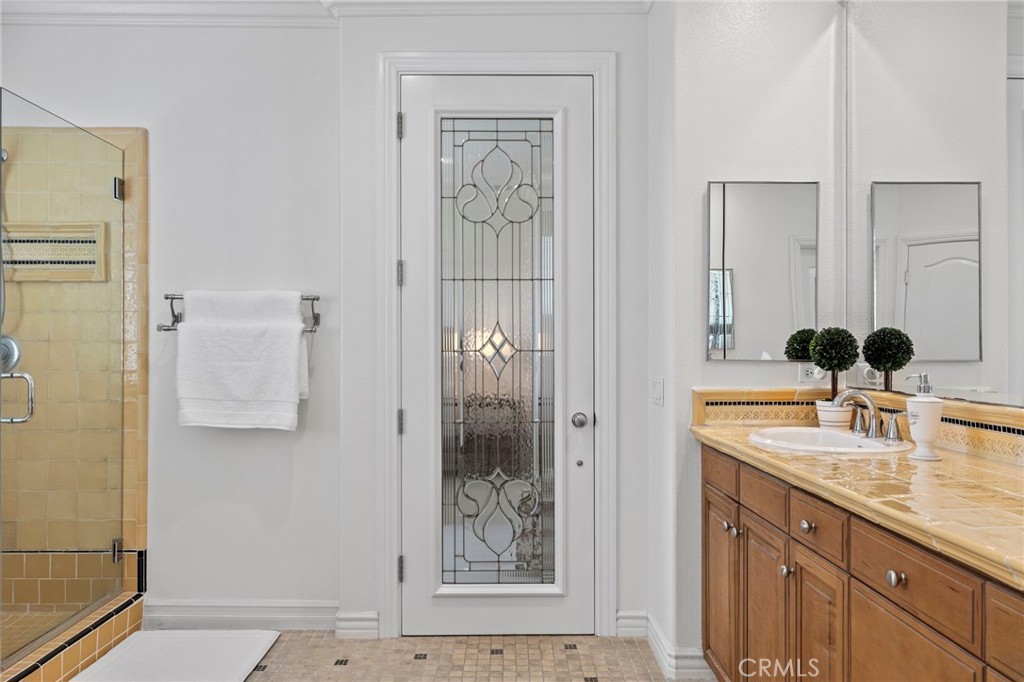 30 Baudin Circle Ladera Ranch, CA 92694 - Photo 33 of 75 a bathroom with a granite countertop sink a mirror and shower