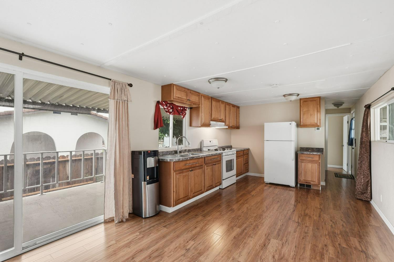 15820 Harlan Road, Unit 85 Lathrop, CA 95330 - Photo 13 of 27 a kitchen with stainless steel appliances granite countertop a refrigerator a stove top oven and wooden floors
