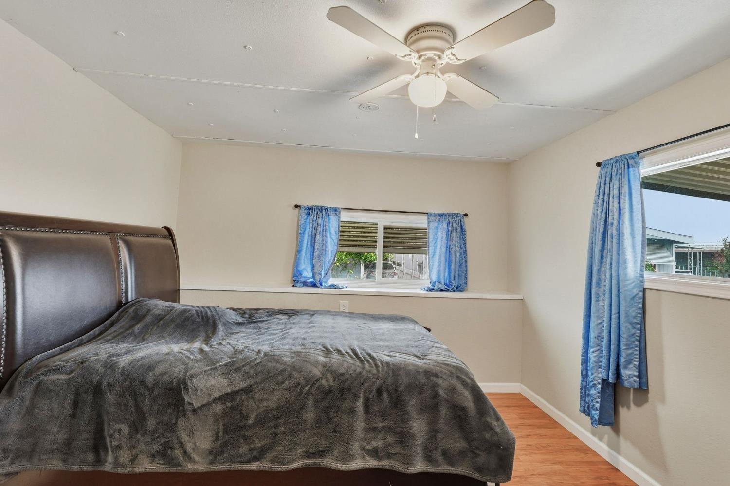 15820 Harlan Road, Unit 85 Lathrop, CA 95330 - Photo 17 of 27 a bedroom with a large bed and a chandelier