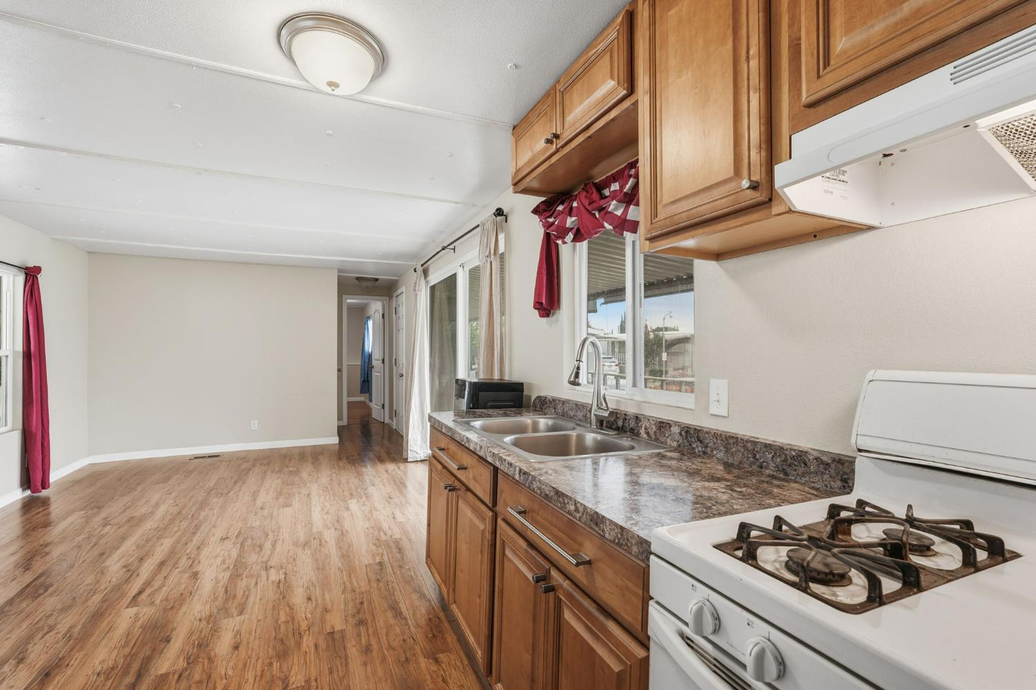 15820 Harlan Road, Unit 85 Lathrop, CA 95330 - Photo 10 of 27 a kitchen that has a stove and a wooden floor
