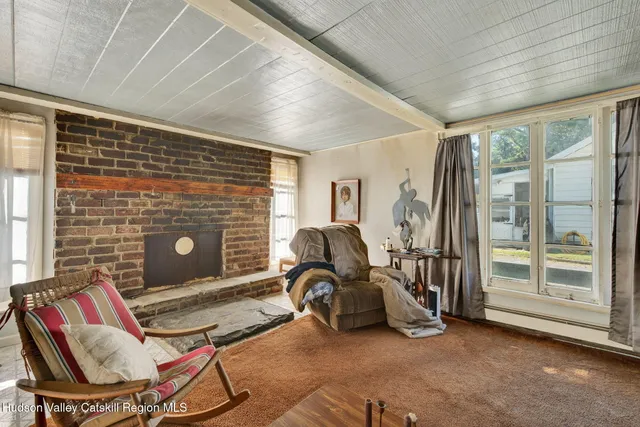a living room with patio furniture and a floor to ceiling window