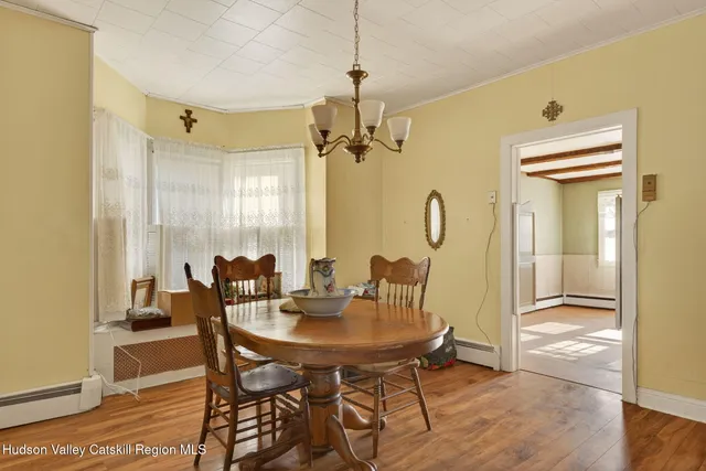 a view of a a dining room with furniture window and wooden floor