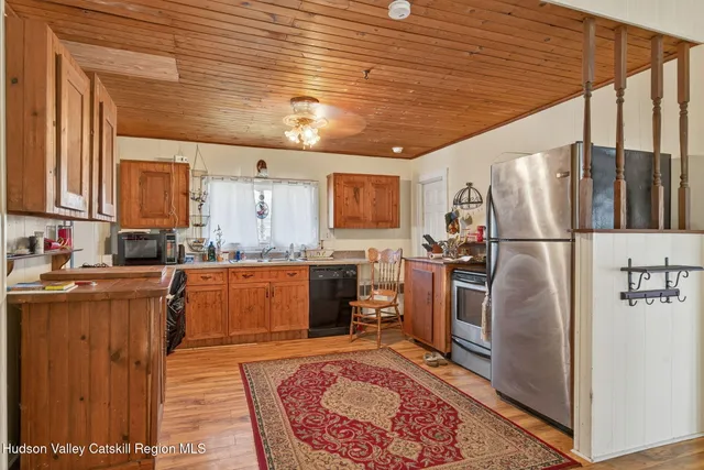 a kitchen with granite countertop stainless steel appliances a refrigerator a stove top oven and sink