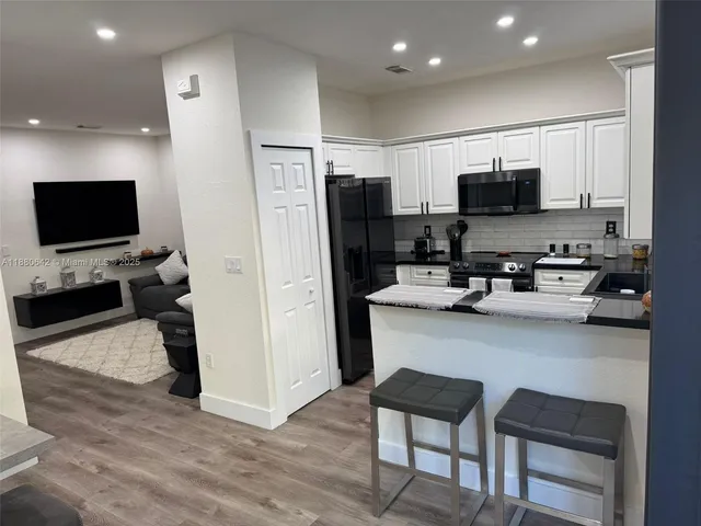 a view of a kitchen with cabinets and wooden floor
