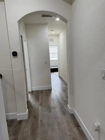 a view of a hallway with wooden floor