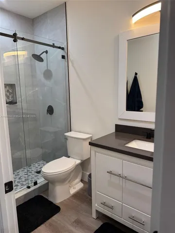 a bathroom with a granite countertop sink a toilet and shower