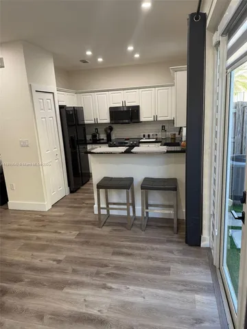 a view of kitchen with stainless steel appliances refrigerator stove microwave and cabinets