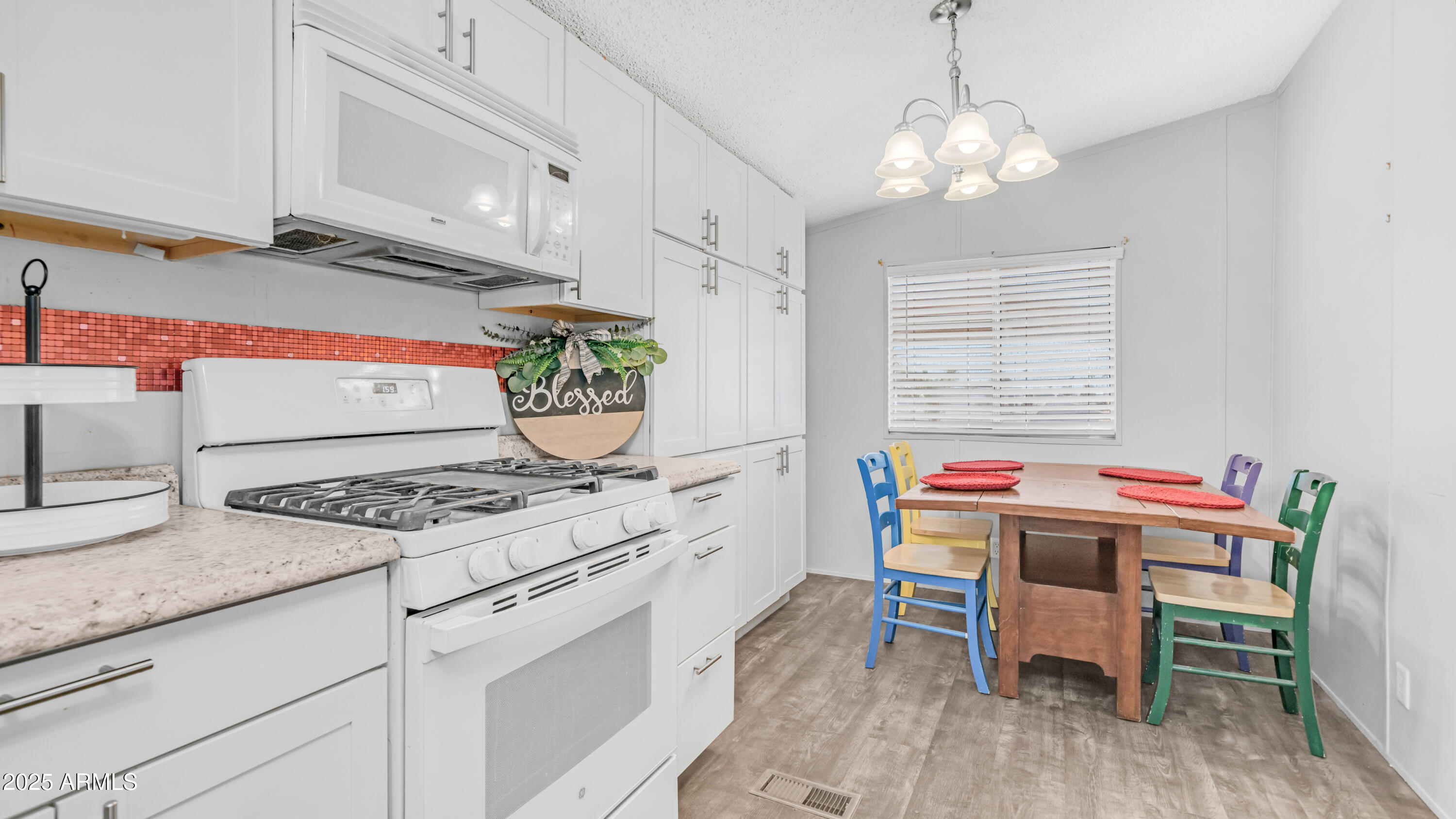 301 South Signal Butte Road, Unit 51 Apache Junction, AZ 85120 - Photo 15 of 32 a kitchen with a stove a table and chairs in it