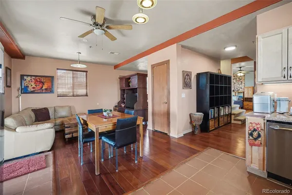 a living room with stainless steel appliances kitchen island granite countertop furniture wooden floor and a view of kitchen