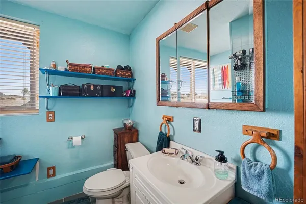 a bathroom with a sink mirror and toilet