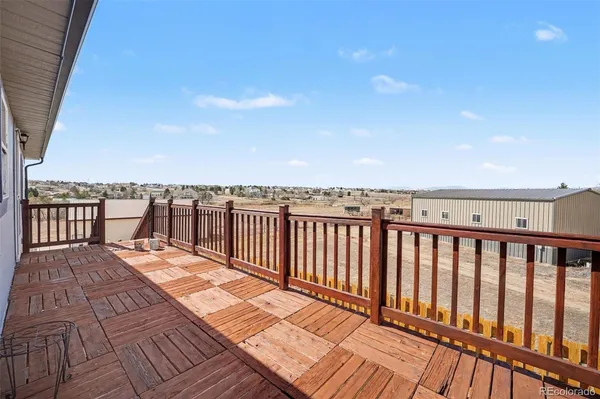 a balcony with wooden floor and city view