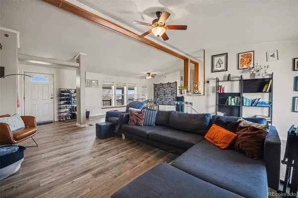 a living room with furniture and a wooden floor