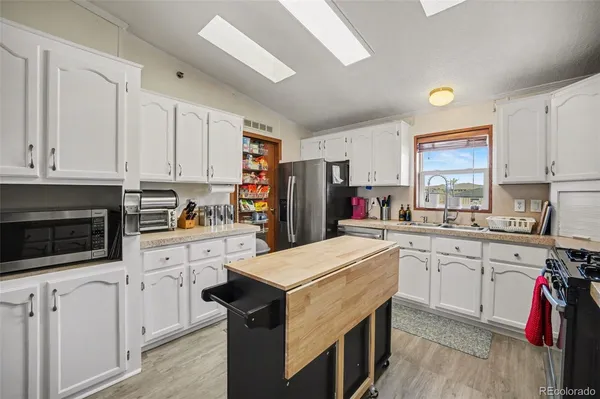 a kitchen with white cabinets and white appliances