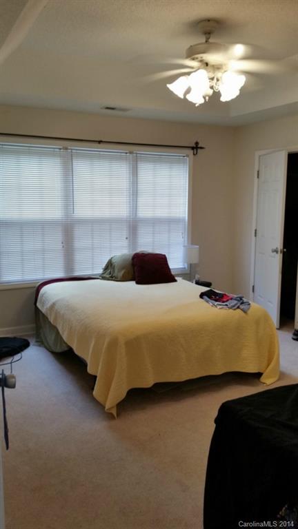 7003 Providence Road South Waxhaw, NC 28173 - Photo 13 of 20 a bedroom with a bed and a chandelier