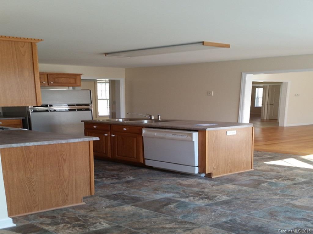 7003 Providence Road South Waxhaw, NC 28173 - Photo 6 of 20 a kitchen with stainless steel appliances kitchen island wooden cabinets and a fireplace