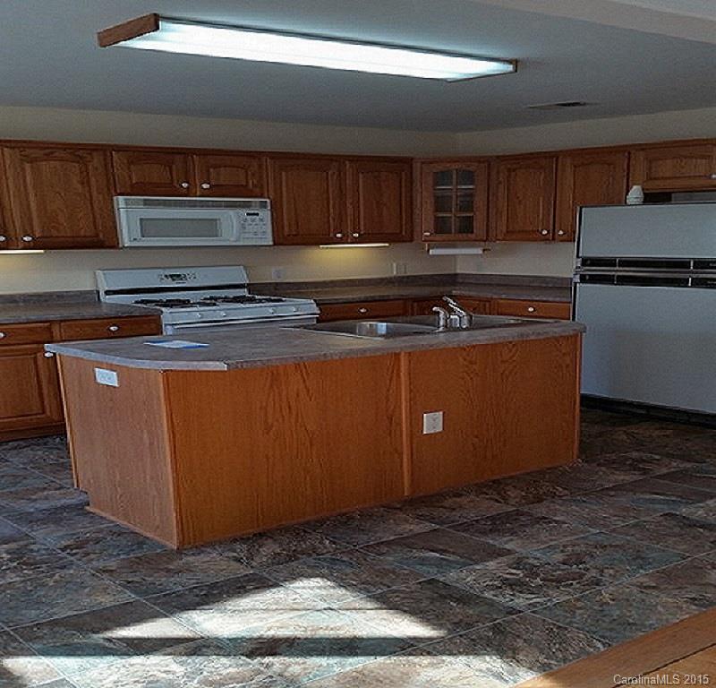 7003 Providence Road South Waxhaw, NC 28173 - Photo 7 of 20 a kitchen with stainless steel appliances granite countertop a stove a refrigerator a sink a microwave and wooden cabinets