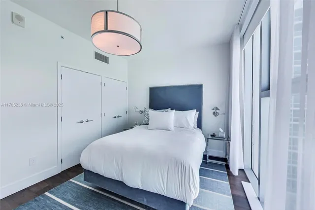 a bedroom with a bed and a chandelier