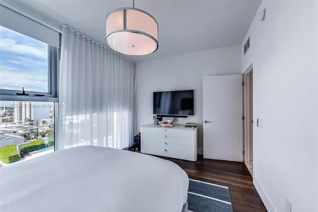 a bedroom with a bed and a television