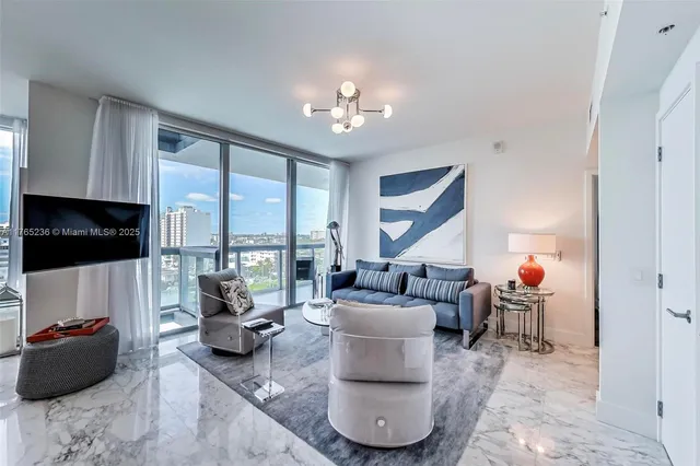 a living room with furniture a flat screen tv and a large window