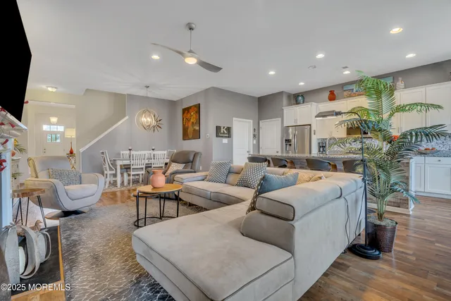 a kitchen with kitchen island granite countertop a sink a stove a dining table and chairs