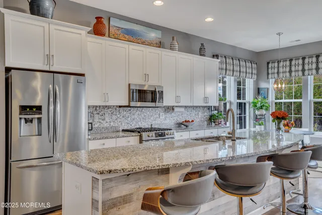a living room with dining table and a chandelier