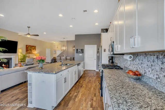a kitchen with stainless steel appliances granite countertop a refrigerator sink stove microwave and cabinets