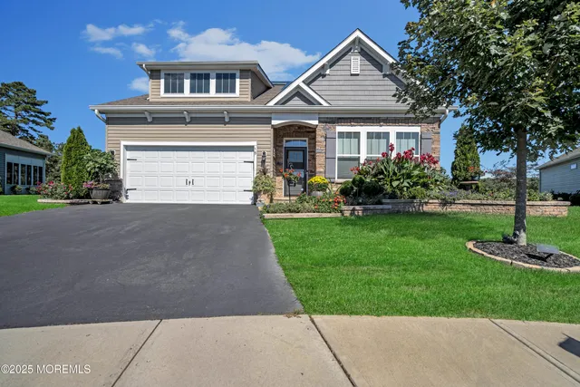 a front view of a house with a yard and trees