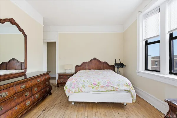 a bedroom with a bed and a dresser with mirror