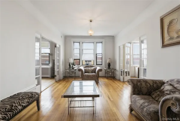 a living room with furniture hard wood floor and a large window