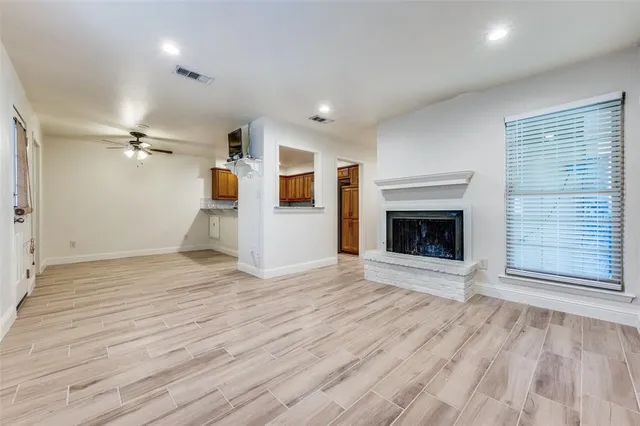 a view of empty room with wooden floor and fireplace