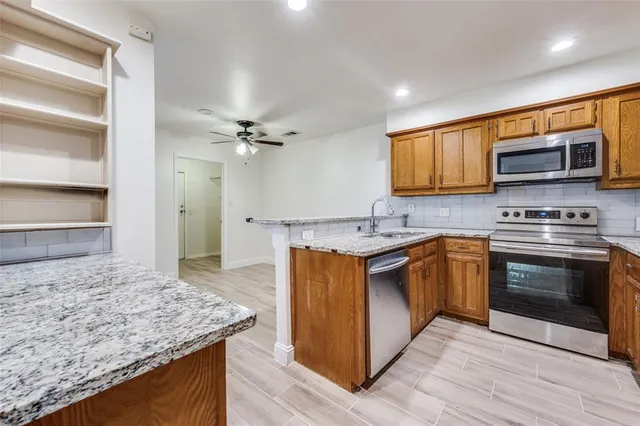 a kitchen with stainless steel appliances granite countertop a sink stove and microwave