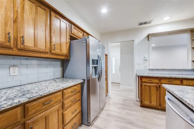 a kitchen with stainless steel appliances granite countertop a refrigerator and a sink