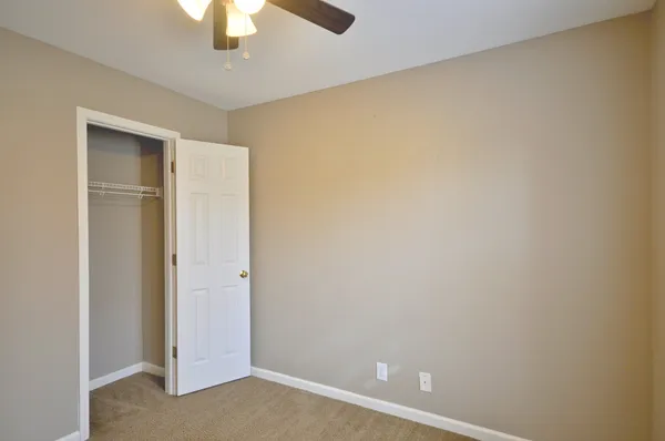 an empty room with a chandelier fan