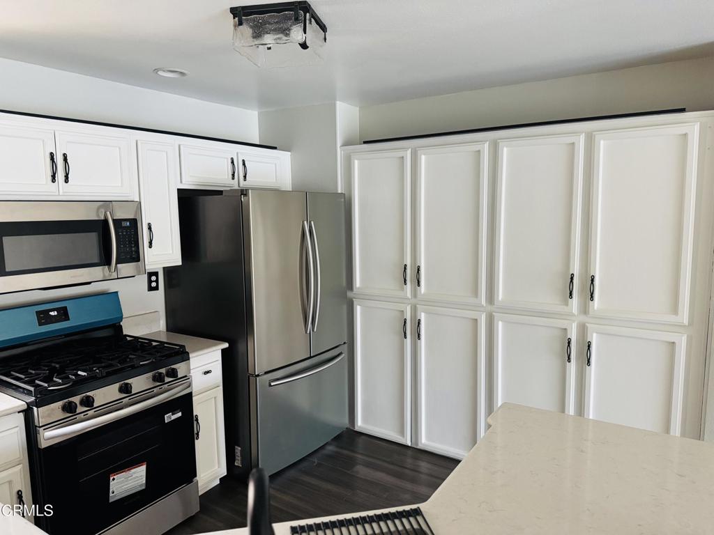 2742 Borchard Road Newbury Park, CA 91320 - Photo 22 of 51 a kitchen with stainless steel appliances a refrigerator a stove and white cabinets