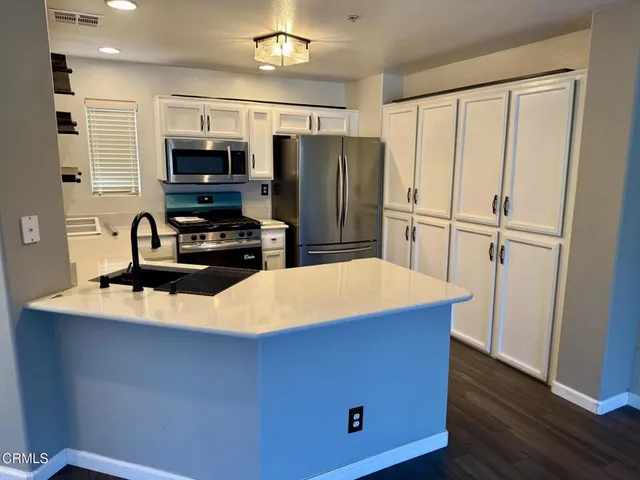 a view of a house with roof and a small yard