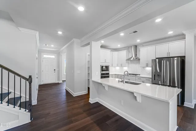 a kitchen with stainless steel appliances a refrigerator and a stove top oven